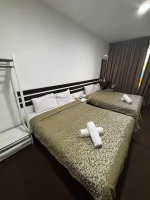 two beds in a hotel room with towels on them at Swing & Pillows - Grand Inn George Town Penang in George Town