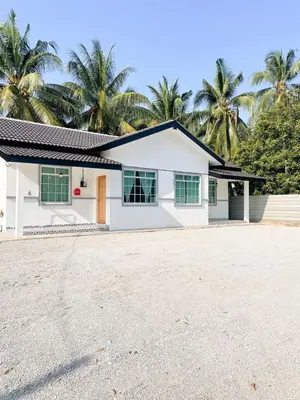 a white house with palm trees in the background at Rumah Huda in Bukit Mertajam