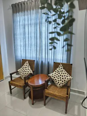 two chairs and a table in front of a curtain at Rumah Huda in Bukit Mertajam