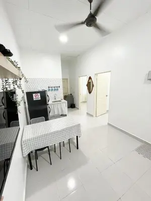 a living room with white tile floors and a ceiling at Rumah Huda in Bukit Mertajam