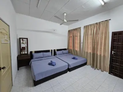 a bedroom with two beds and a ceiling fan at Pera House Hostel in Ipoh
