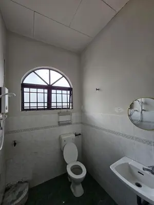a bathroom with a toilet and a sink and a window at Pera House Hostel in Ipoh
