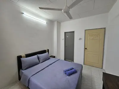 a bedroom with a bed with blue pillows on it at Pera House Hostel in Ipoh