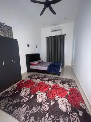 a bedroom with a bed with red roses on a carpet at Hasya Guesthouse in Seri Iskandar