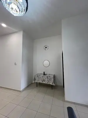 a room with a table and a clock on the wall at Hasya Guesthouse in Seri Iskandar