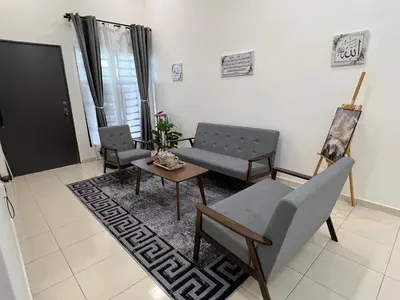 a living room with two chairs and a table at Hasya Guesthouse in Seri Iskandar