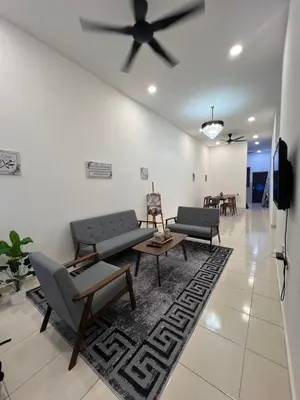 a living room with couches and a ceiling fan at Hasya Guesthouse in Seri Iskandar