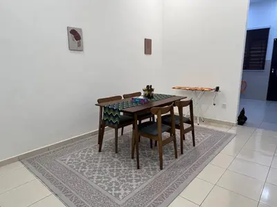 a dining room table and chairs on a rug at Hasya Guesthouse in Seri Iskandar