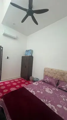 a bedroom with a bed with a ceiling fan at Hasya Guesthouse in Seri Iskandar
