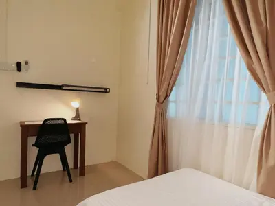 a bedroom with a bed and a desk and a window at Cozy Suite with Twin Beds & Lounge in Nibung Tebal