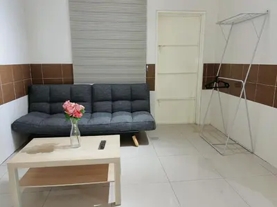 a living room with a blue couch and a table at Cozy Suite with Twin Beds & Lounge in Nibung Tebal
