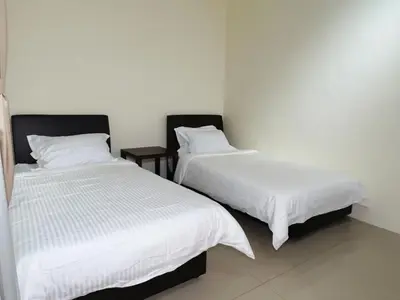 two beds sitting next to each other in a room at Cozy Suite with Twin Beds & Lounge in Nibung Tebal
