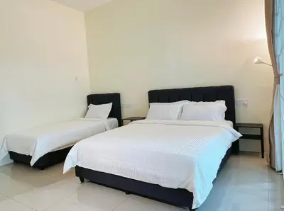 a bedroom with two beds with white sheets at Cozy Family Room with Large Balcony in Nibung Tebal