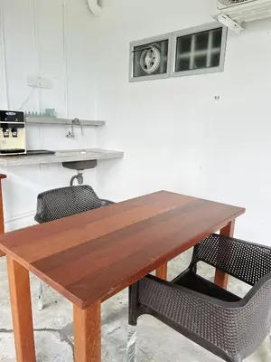 a wooden table in a kitchen with two chairs at Cozy Family Room with Large Balcony in Nibung Tebal