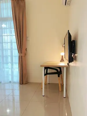 a desk with a television and a chair in a room at Cozy Family Room with Large Balcony in Nibung Tebal