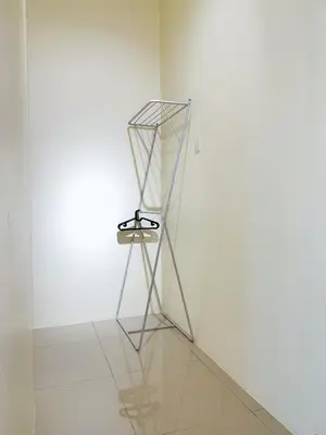 a metal stand in a room with a white wall at Cozy Family Room with Large Balcony in Nibung Tebal