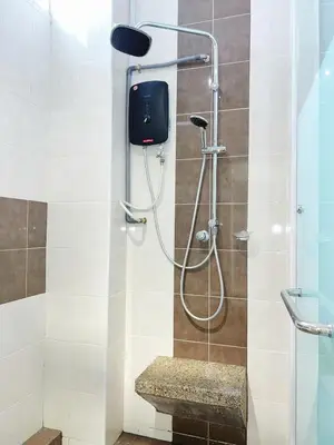 a shower with a bench in a bathroom at Cozy 2-Bedroom Balcony Suite with Living Room in Nibung Tebal
