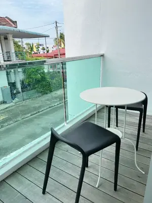 a table and a chair sitting on a balcony at Cozy 2-Bedroom Balcony Suite with Living Room in Nibung Tebal