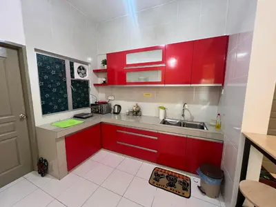 a small kitchen with red cabinets and a sink at StayIndah Homestay Cameron Highlands in Tanah Rata