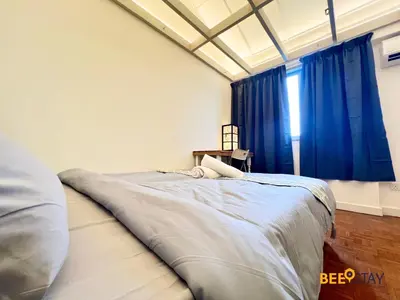 a bedroom with a large bed with blue curtains at SS2 Landed in Petaling Jaya for 8 Pax in Gua Sai