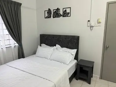 a bedroom with a white bed with a black headboard at Wareesha Homestay, Corner Lot With Netflix in Padang Serai