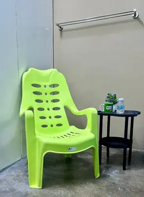 a green chair sitting next to a table at Little Stay Inn in Taiping
