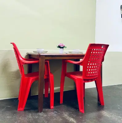 a wooden table with two red chairs next to it at Little Stay Inn in Taiping