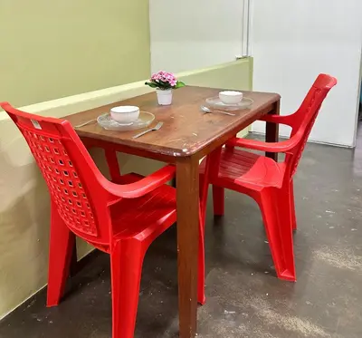 a wooden table with two red chairs around it at Little Stay Inn in Taiping