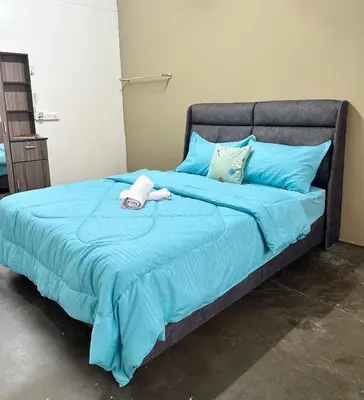 a blue bed with a stuffed animal on it at Little Stay Inn in Taiping