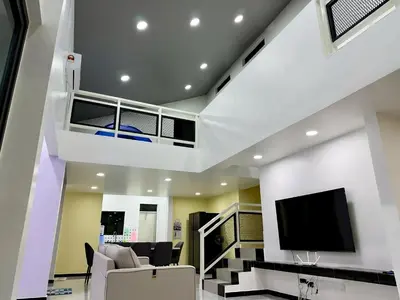 a living room with a tv and a staircase at \u5feb\u4e50\u5ba2\u6808 Sentosa Cottage in Raub