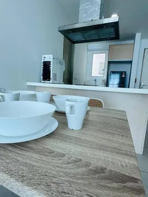 a kitchen counter with white bowls on a wooden table at Seaview Condo A31 #Queensbay#SPICE in Bayan Lepas