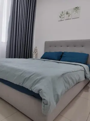 a bedroom with a large bed with blue pillows at Studio Unit Marc Residence in Bukit Mertajam