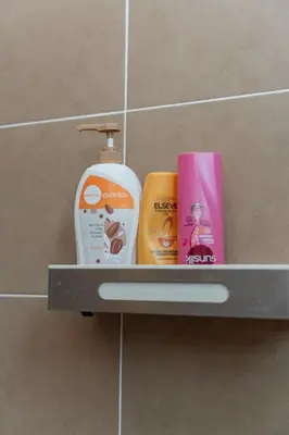a shelf in a bathroom with products on it at Bright & Airy Double-Storey Retreat 4BR in Simpang Ampat