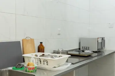 a kitchen counter with a sink and a microwave at Bright & Airy Double-Storey Retreat 4BR in Simpang Ampat