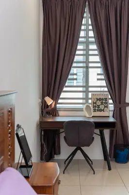 a desk in front of a window with a laptop at Bright & Airy Double-Storey Retreat 4BR in Simpang Ampat