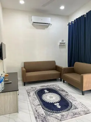 a living room with two couches and a rug at Neera Rest House in Gua Sai