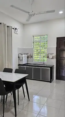 a kitchen with a table and a counter top at Neera Rest House in Gua Sai