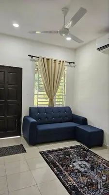 a blue couch in a living room with a window at Neera Rest House in Gua Sai
