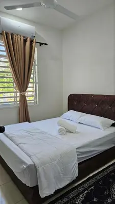 a bedroom with a large white bed with a window at Neera Rest House in Gua Sai