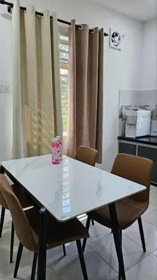 a white table with chairs in a room with a window at Neera Rest House in Gua Sai