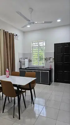 a kitchen with a table and chairs in a room at Neera Rest House in Gua Sai