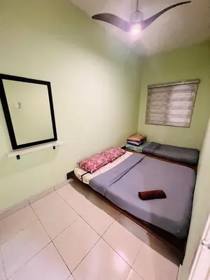a bed in a room with a ceiling fan at Rayyan'Homestay PMCJ in Tanah Rata
