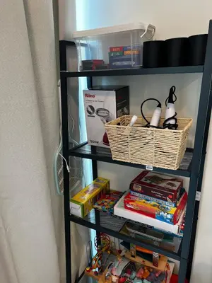 a book shelf with books and other items on it at AP Homestay in Sekincan