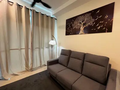 a living room with a couch and a tree picture on the wall at AP Homestay in Sekincan