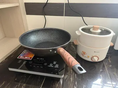 a pan on top of a stove with a bucket at Serenity Haven Family Stay Ipoh 10-12 Pax in Ipoh