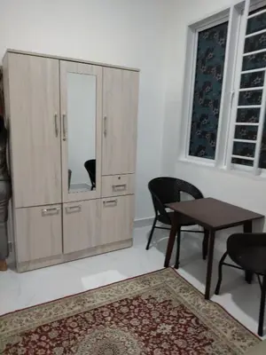a room with a large cabinet with a table and chairs at Makwan Homestay D in Kubang Semang