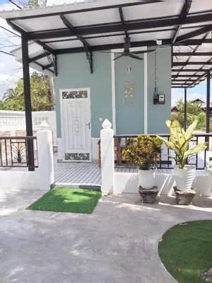 a house with a porch with a green lawn at Makwan Homestay D in Kubang Semang