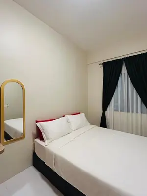 a bedroom with a large bed and a mirror at WiU Cottage, Seri Iskandar in Seri Iskandar