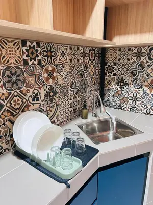 a kitchen with a sink and a counter with plates at WiU Cottage, Seri Iskandar in Seri Iskandar