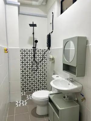 a bathroom with a toilet and a sink and a mirror at WiU Cottage, Seri Iskandar in Seri Iskandar